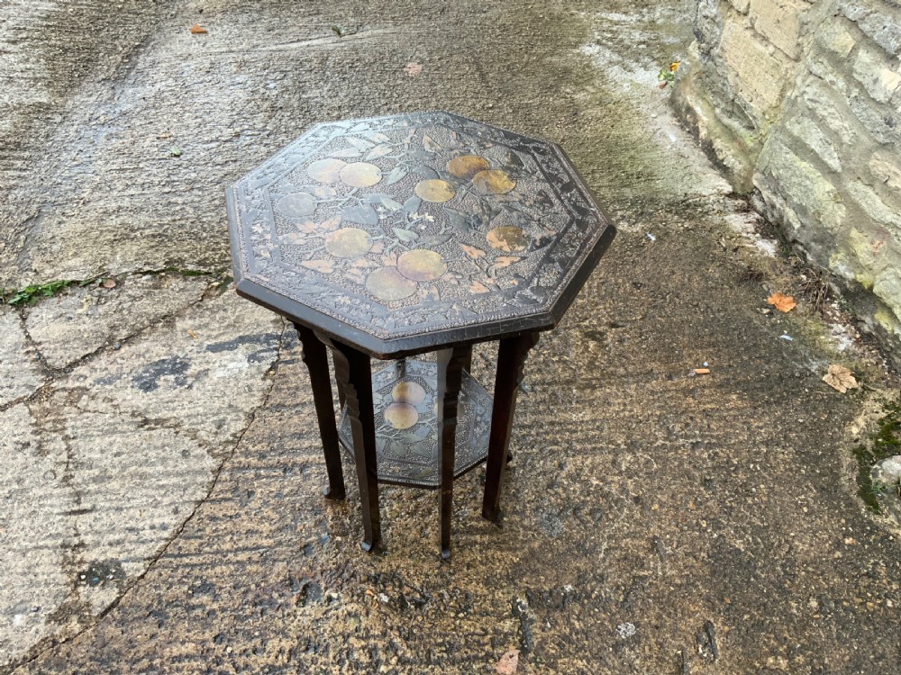 An octagonal dark wood Arts and Crafts occasional table featuring hand-painted fruit motifs on the top surface and lower tier. View VI