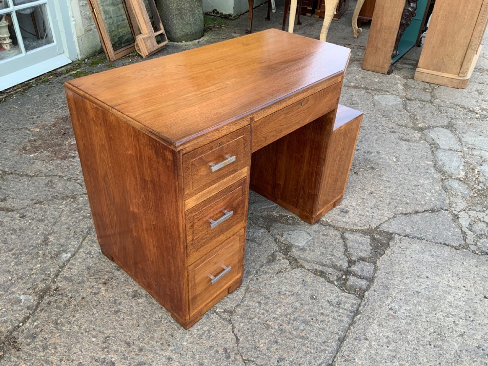 An Art Deco walnut desk featuring a left-hand pedestal of three drawers, a central kneehole drawer, an asymmetric stepped side tier, and metallic bar handles. View IV
