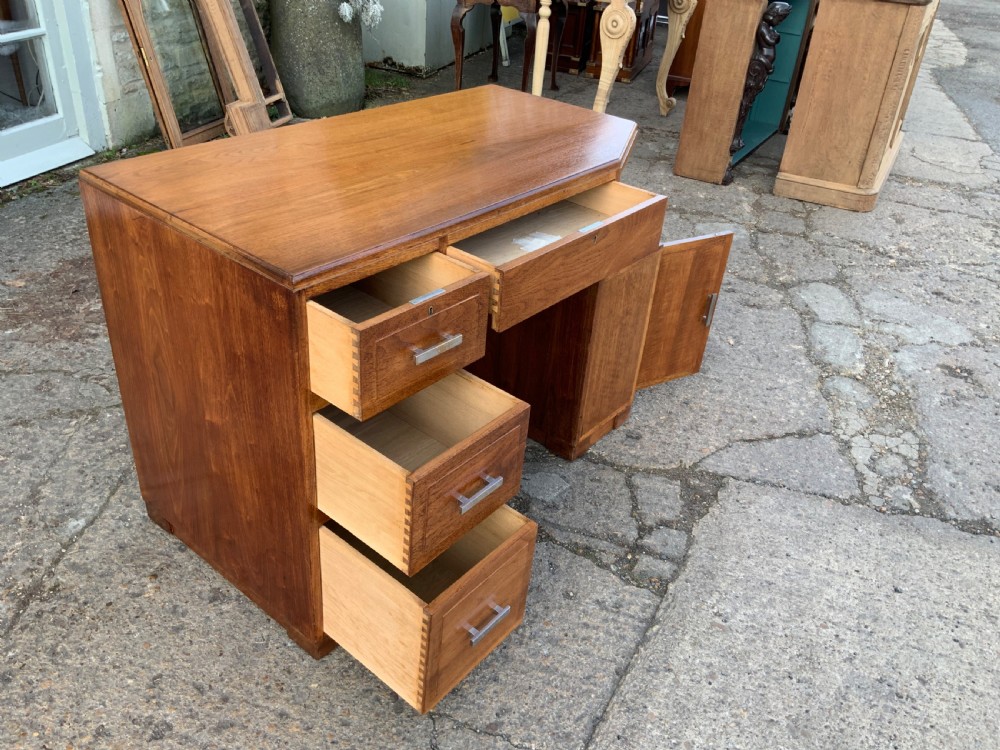 An Art Deco walnut desk featuring a left-hand pedestal of three drawers, a central kneehole drawer, an asymmetric stepped side tier, and metallic bar handles. View VIII