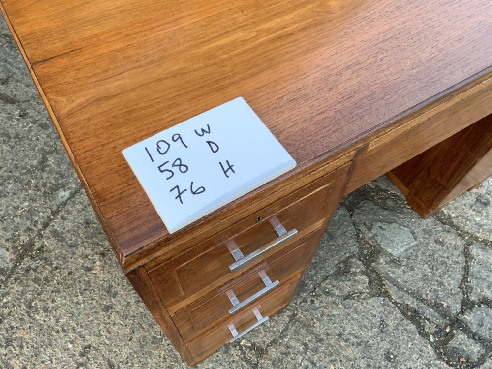 An Art Deco walnut desk featuring a left-hand pedestal of three drawers, a central kneehole drawer, an asymmetric stepped side tier, and metallic bar handles. View XIII