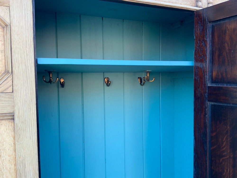 A light oak double wardrobe featuring geometric panelled doors, octagonal raised bosses, two base drawers, and turned legs. View VIII