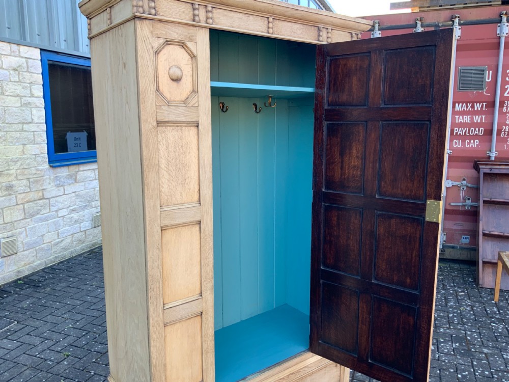 A light oak double wardrobe featuring geometric panelled doors, octagonal raised bosses, two base drawers, and turned legs. View IX