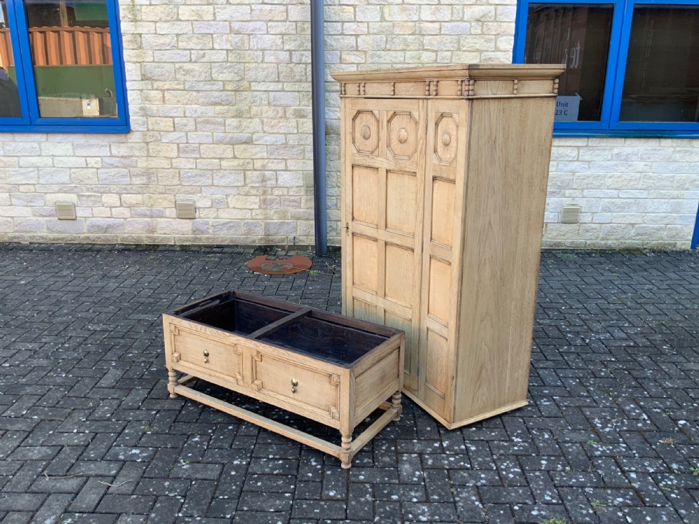 A light oak double wardrobe featuring geometric panelled doors, octagonal raised bosses, two base drawers, and turned legs. View XII