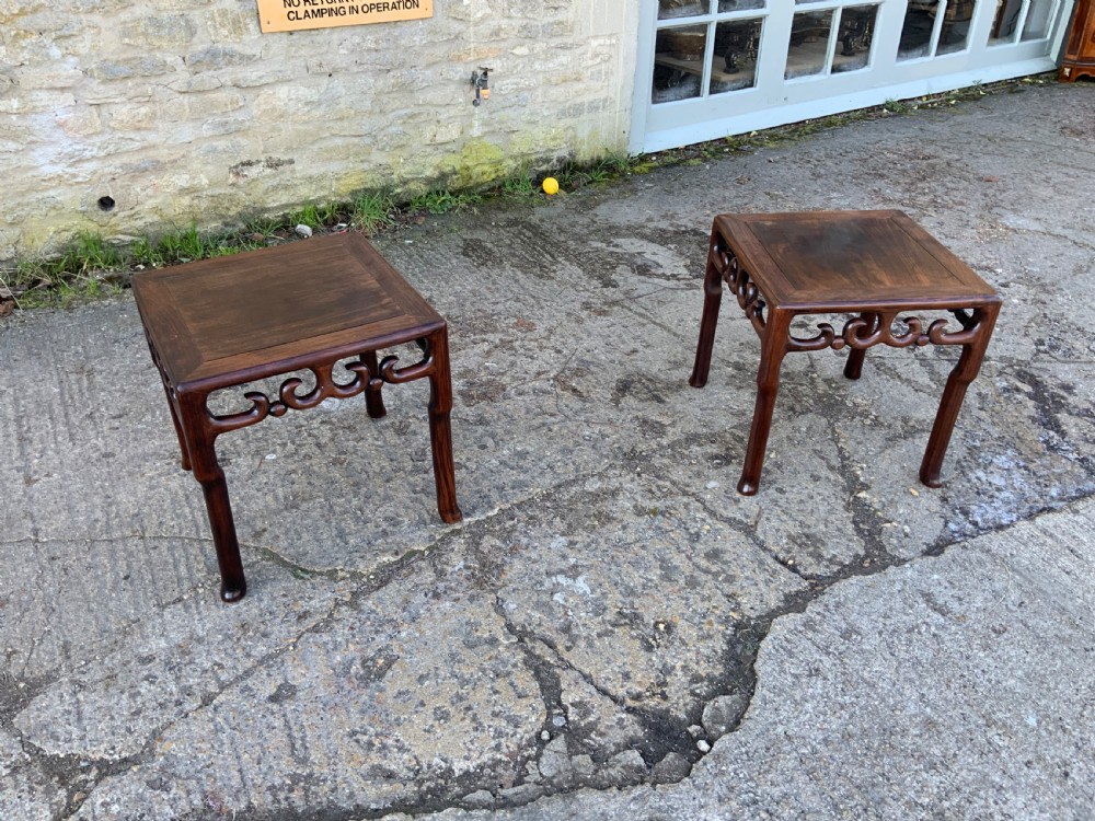A pair of low square dark brown hardwood side tables featuring carved openwork scroll aprons and shaped legs. View V