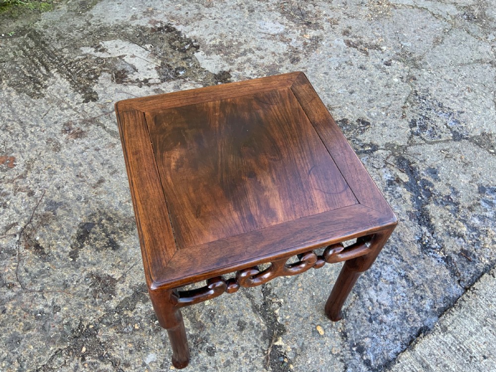 A pair of low square dark brown hardwood side tables featuring carved openwork scroll aprons and shaped legs. View VII