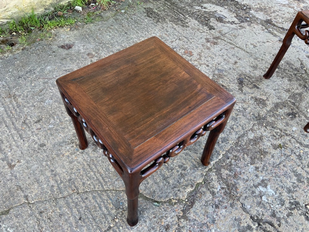 A pair of low square dark brown hardwood side tables featuring carved openwork scroll aprons and shaped legs. View VIII