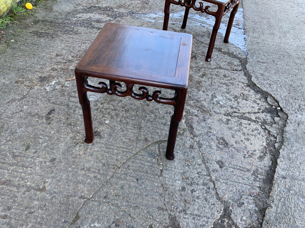 A pair of low square dark brown hardwood side tables featuring carved openwork scroll aprons and shaped legs. View IX