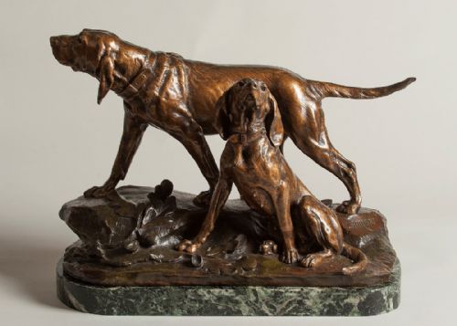 fig 1. A French bronze sculpture depicting two alert hunting hounds standing and sitting on a rocky terrain base mounted on a green marble plinth.