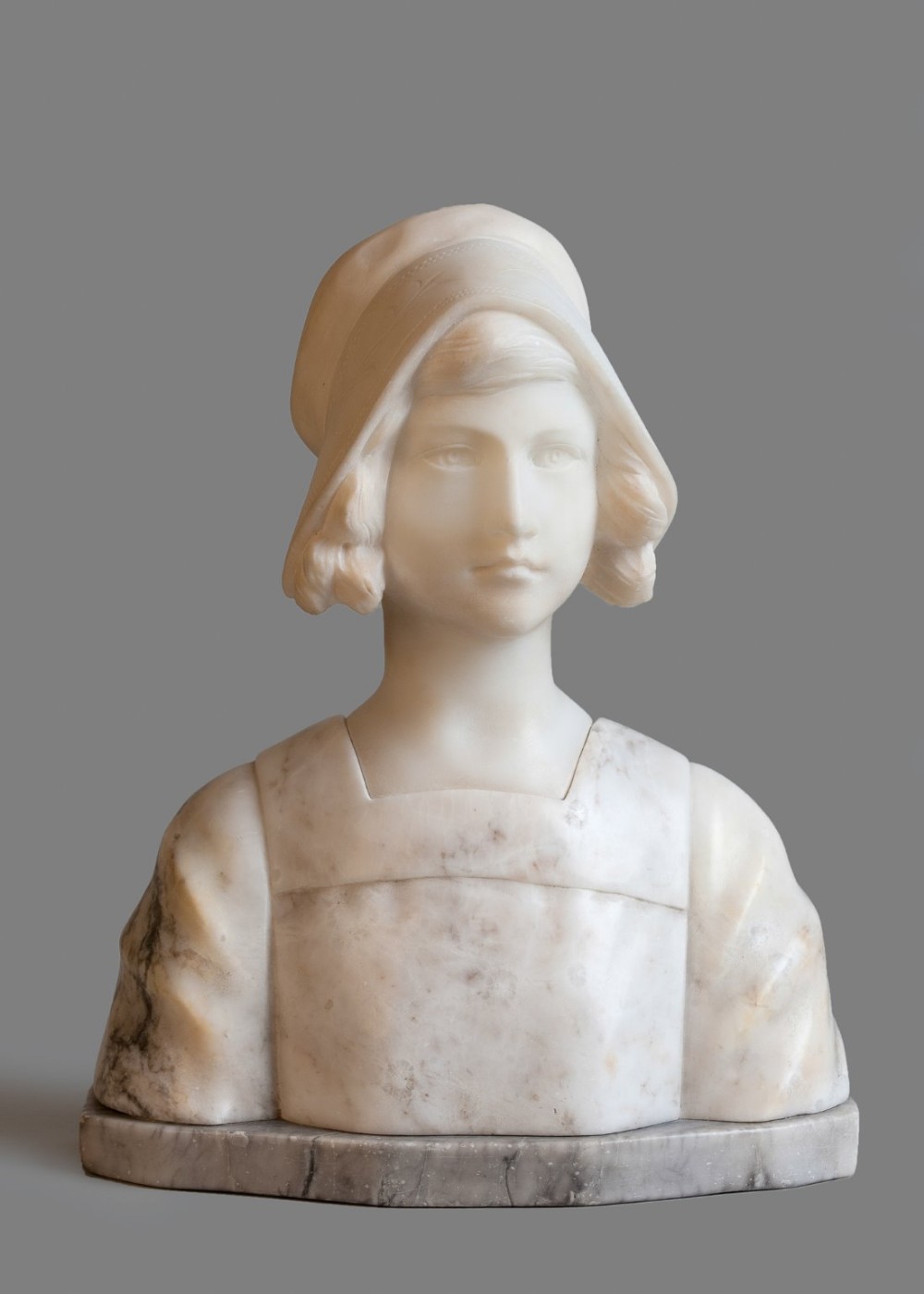 French carved alabaster sculpture of a female set on a grey mottled base.