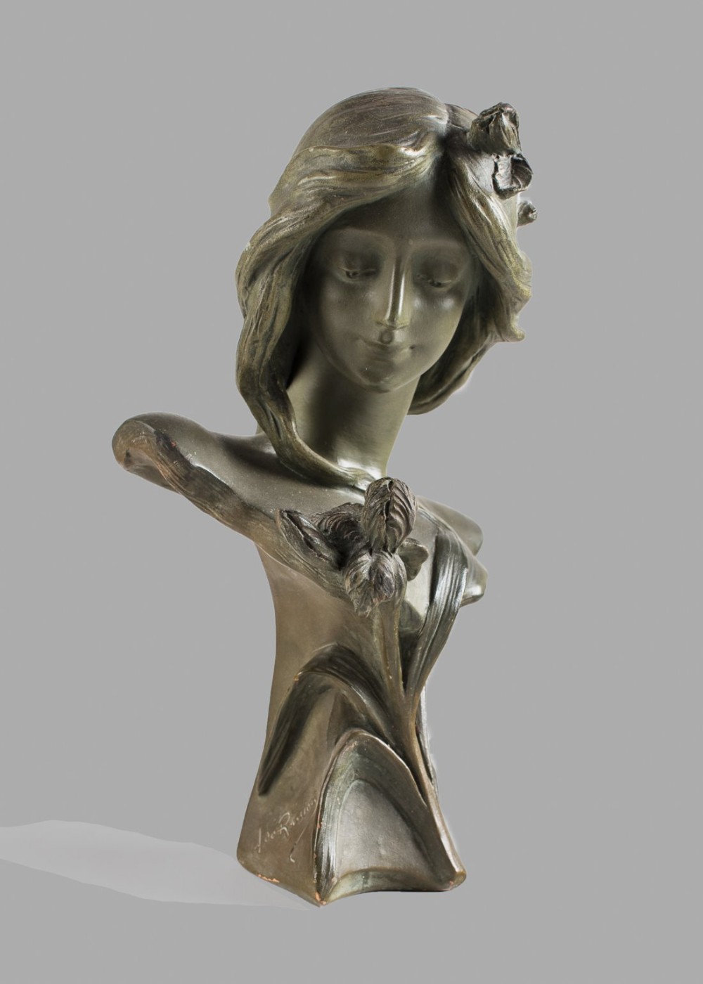 French Art Nouveau patinated terracotta bust depicting a young woman with flowing hair decorated with floral details.