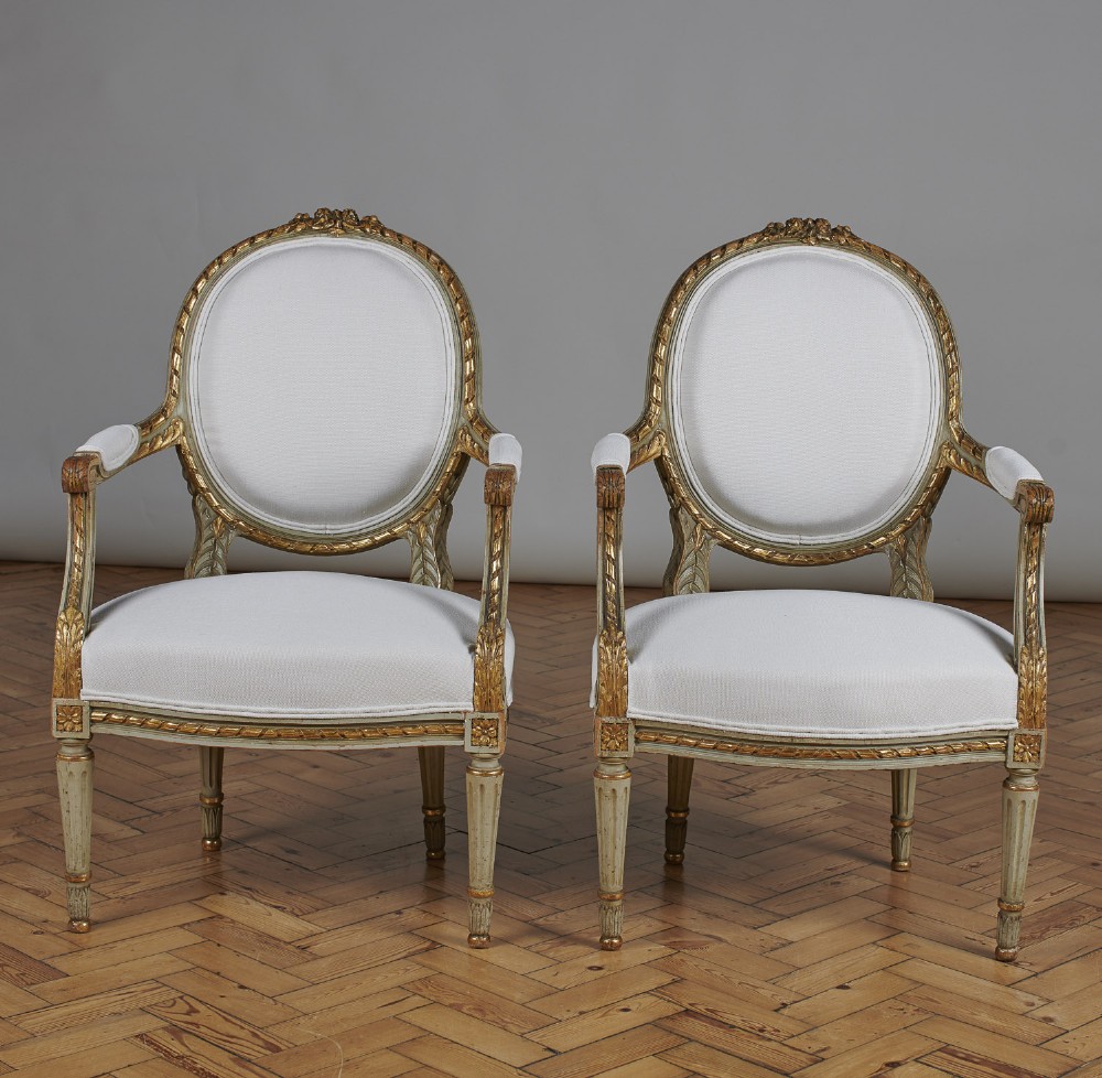 Pair Of French Louis XVI Style Painted And Gilt Cabriolet Armchairs.