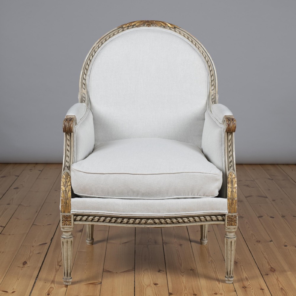 Late 19th century French Louis XVI Style Painted And Gilt Bergere Armchair.