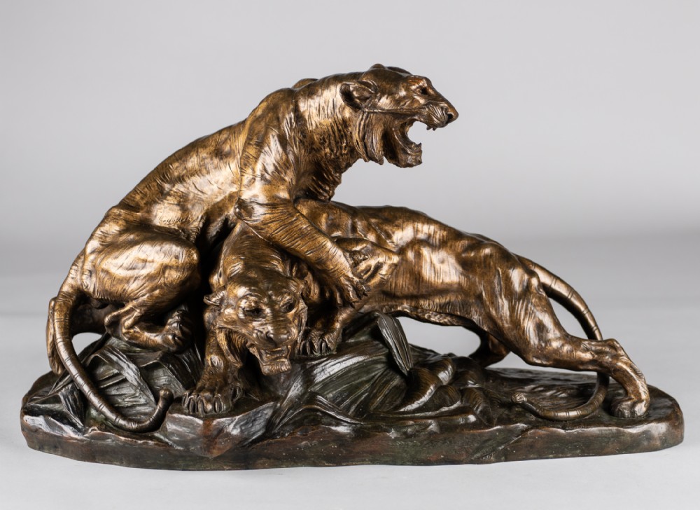 A 19th-century patinated bronze sculpture depicting two tigers interacting on a naturalistic leaf-lined base.