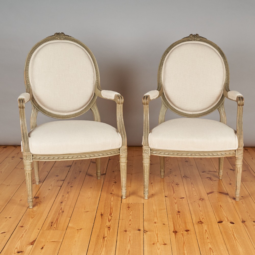 A pair of Large French Louis XVI style painted upholstered armchairs.