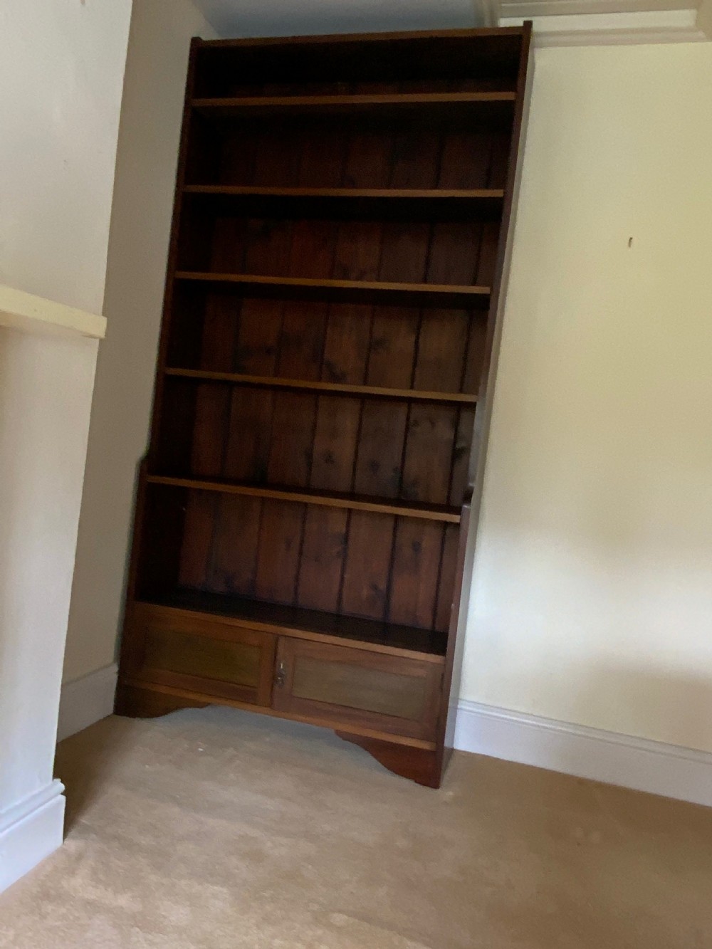 A tall antique dark mahogany open bookcase featuring multiple exposed shelves above a two-door base cupboard. View III