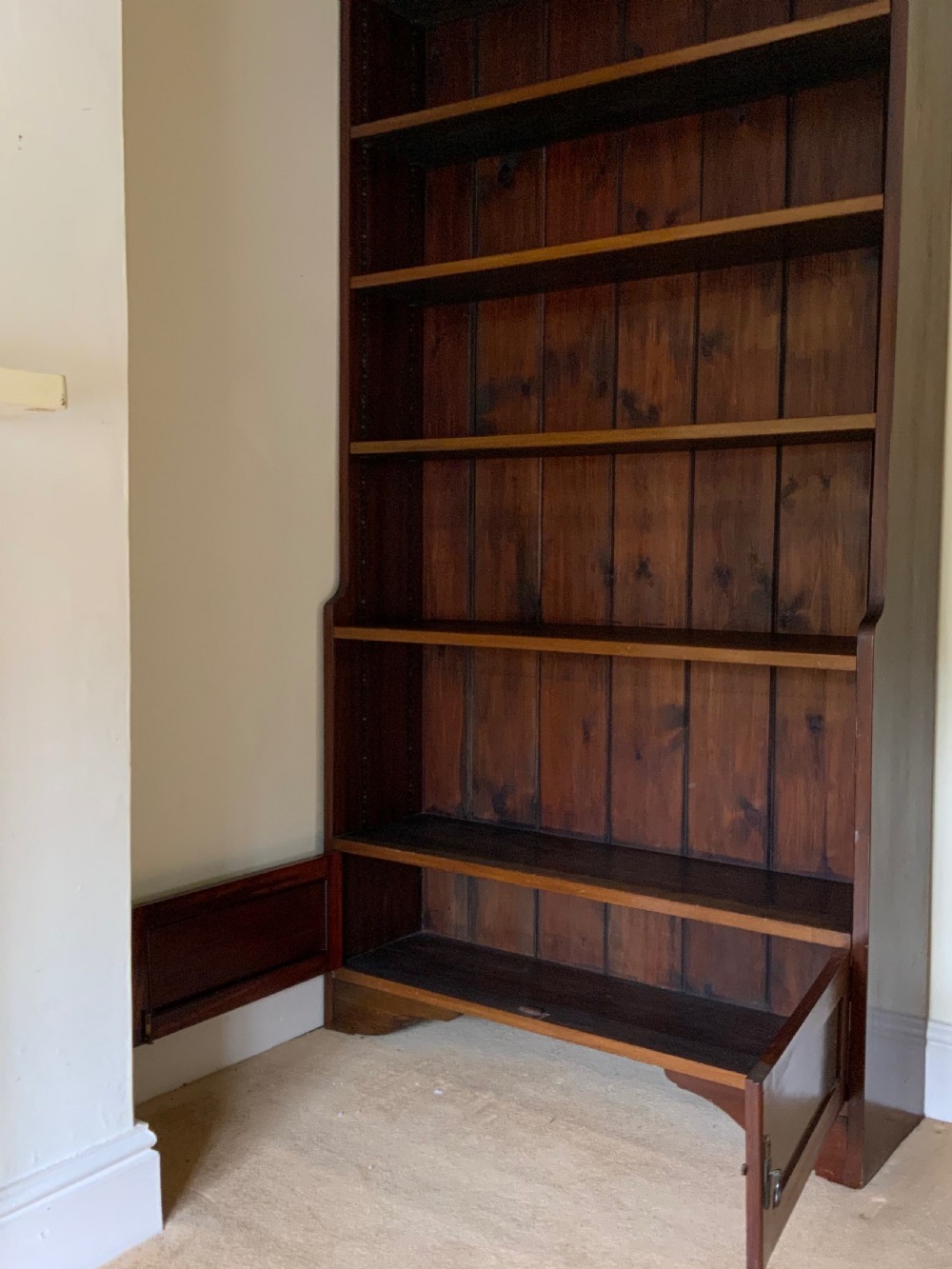 A tall antique dark mahogany open bookcase featuring multiple exposed shelves above a two-door base cupboard. View IV