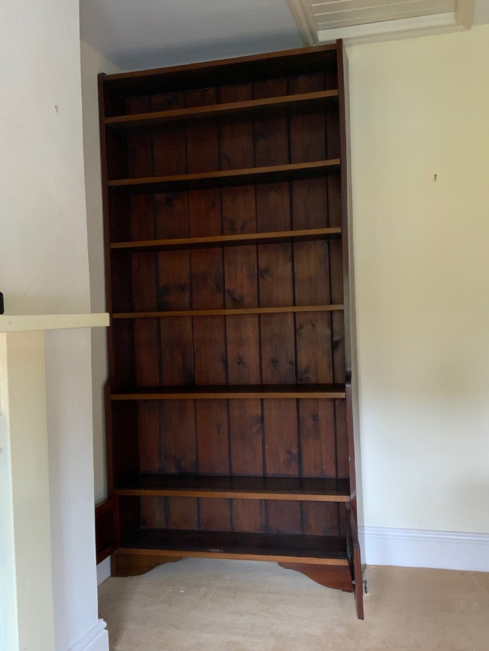 A tall antique dark mahogany open bookcase featuring multiple exposed shelves above a two-door base cupboard. View VI
