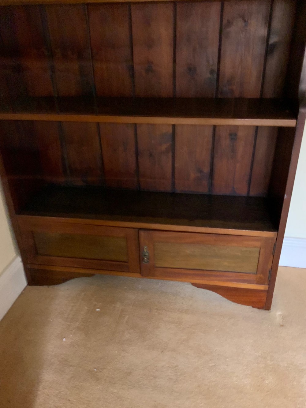 A tall antique dark mahogany open bookcase featuring multiple exposed shelves above a two-door base cupboard. View VII