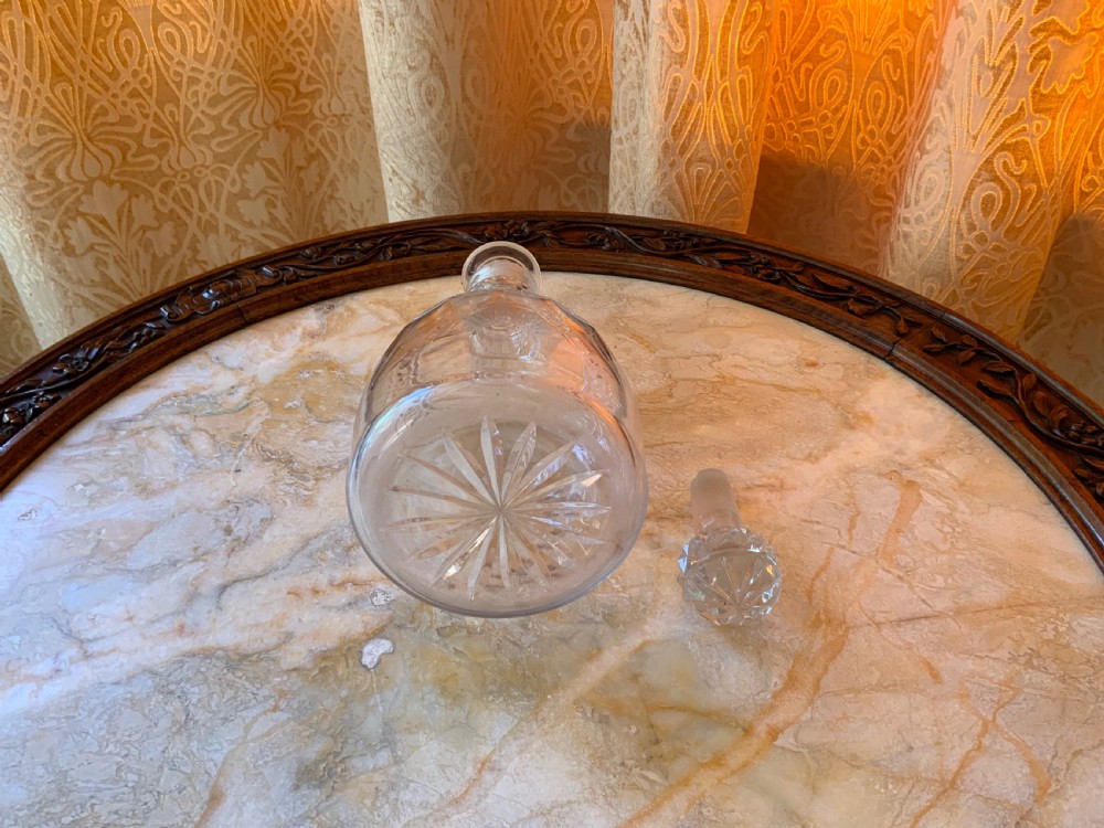 A clear Georgian cut glass decanter featuring three neck rings, a diamond cut band, and a matching mushroom-shaped faceted stopper. View IX