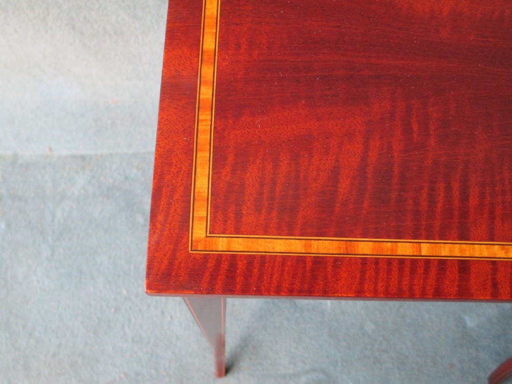 A set of three graduated mahogany nesting tables featuring satinwood stringing inlay along the tops and slender, slightly splayed legs. View III