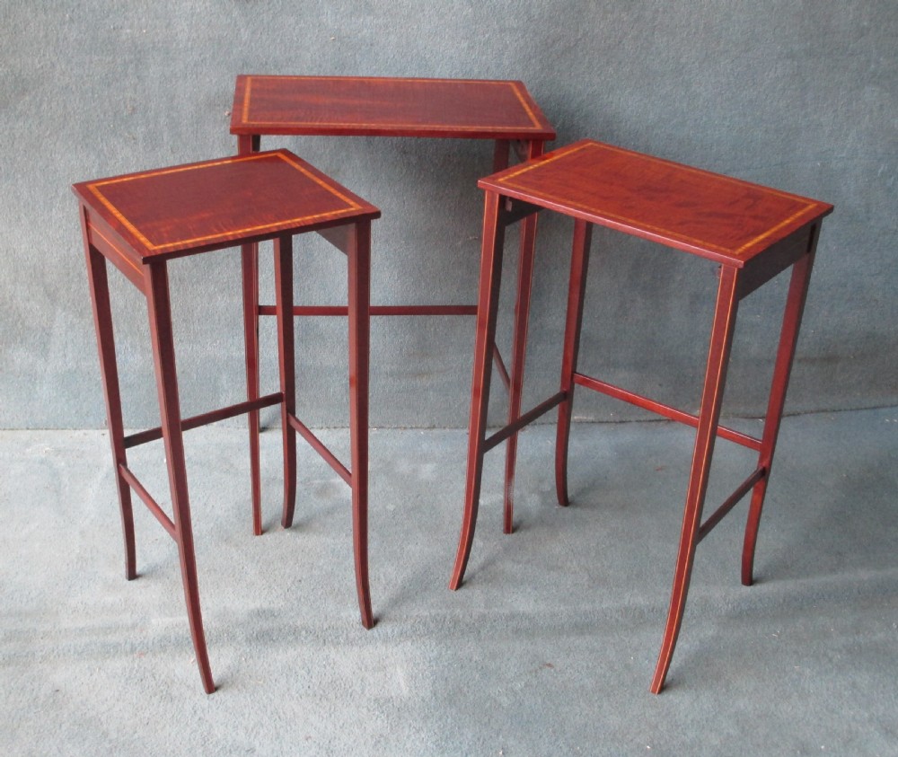 A set of three graduated mahogany nesting tables featuring satinwood stringing inlay along the tops and slender, slightly splayed legs. View IV