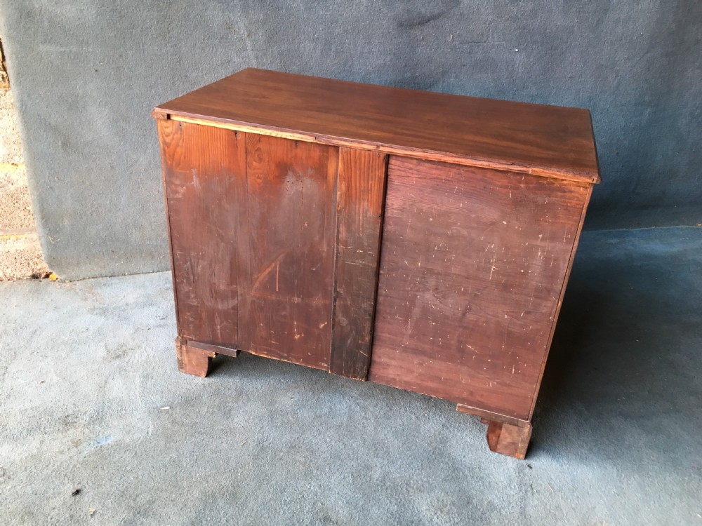 A Georgian style mahogany kneehole desk featuring a flat top, seven pedestal drawers with brass handles, a central recessed cupboard, and bracket feet. View V