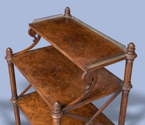 fig 1. An antique walnut tiered whatnot with X-frame sides, turned columns, brass castors, and a small top shelf with a brass gallery rail.