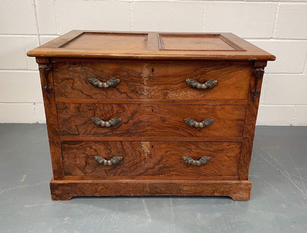 A low antique walnut chest of drawers featuring three full-width drawers with decorative cast metal handles and a panelled top. View III