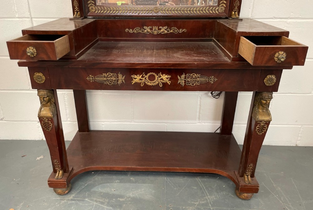 A French Empire style dark mahogany dressing table featuring gilded bronze ormolu mounts, a pediment mirror frame, small side drawers, and a lower shelf. View III