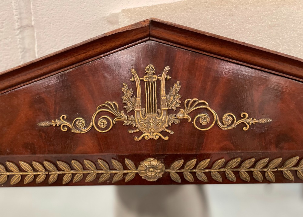 A French Empire style dark mahogany dressing table featuring gilded bronze ormolu mounts, a pediment mirror frame, small side drawers, and a lower shelf. View IV