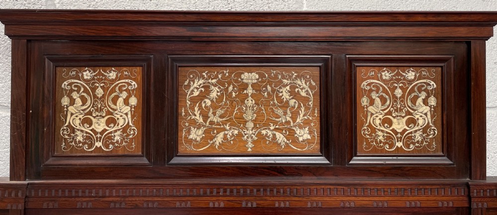 An Aesthetic Movement dark rosewood side cabinet featuring intricate arabesque marquetry inlay panels, a tiered superstructure with central mirror, and turned legs with an open lower shelf. View VI