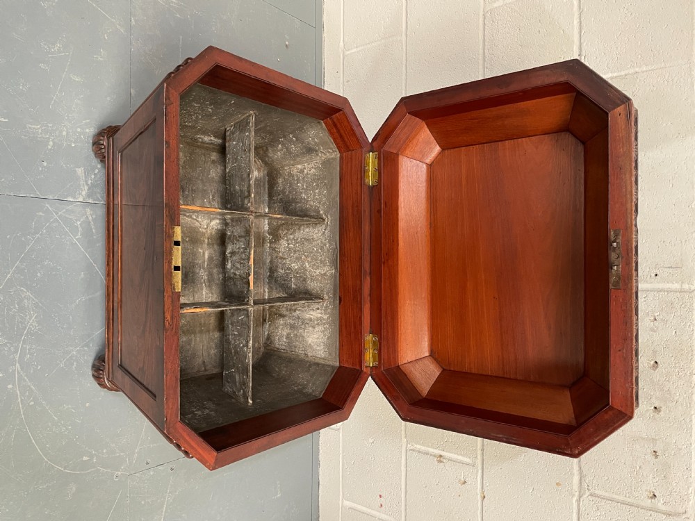 A late Georgian mahogany sarcophagus-form wine cooler featuring carved acanthus detailing, reeded corners, and turned gadrooned feet. View II