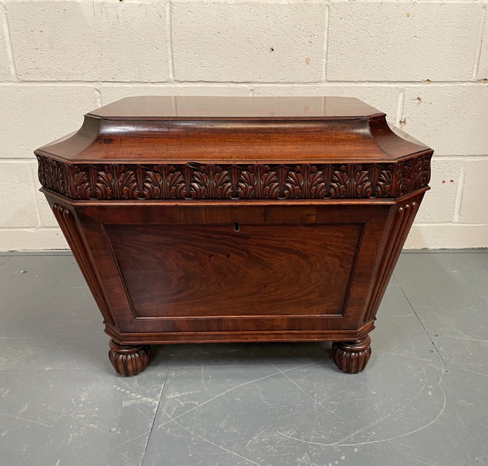 A late Georgian mahogany sarcophagus-form wine cooler featuring carved acanthus detailing, reeded corners, and turned gadrooned feet. View III