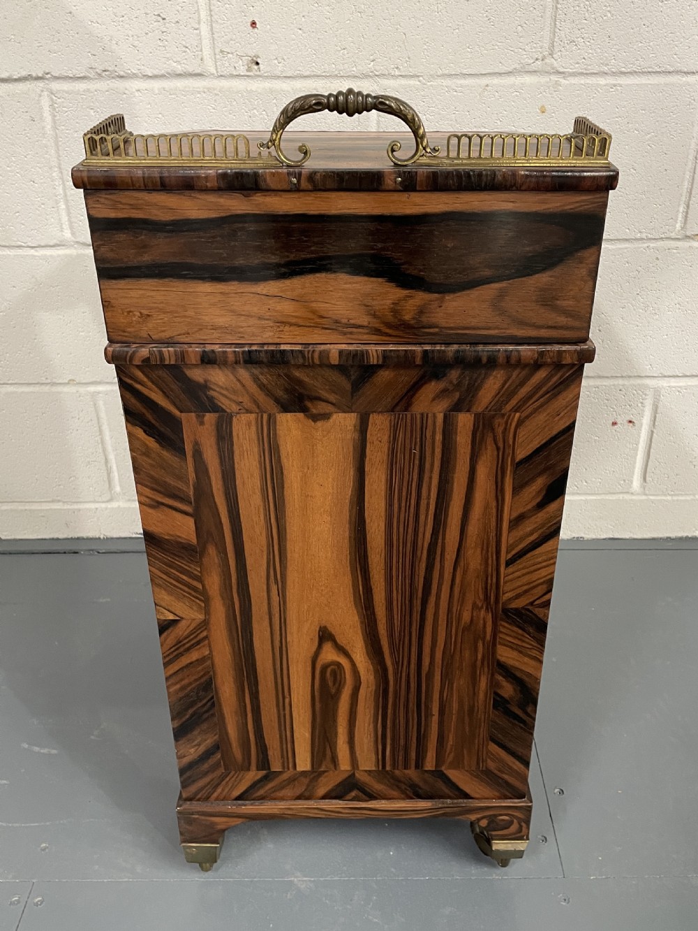 A Regency period coromandel Davenport desk featuring a slanted leather inset writing top, top brass gallery, turned wood knobs, and side drawers on brass castors. View V
