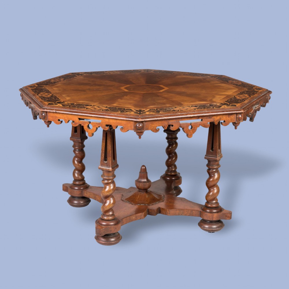 A mid-nineteenth-century octagonal walnut centre table featuring geometric marquetry, a carved apron, spiral-twist legs, and a central finial stretcher.