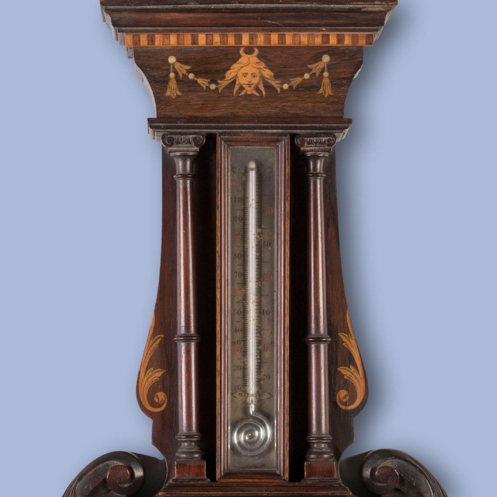 A Neoclassical mahogany wall barometer featuring detailed marquetry inlay of classical figures, a thermometer tube, and a circular weather dial. View II