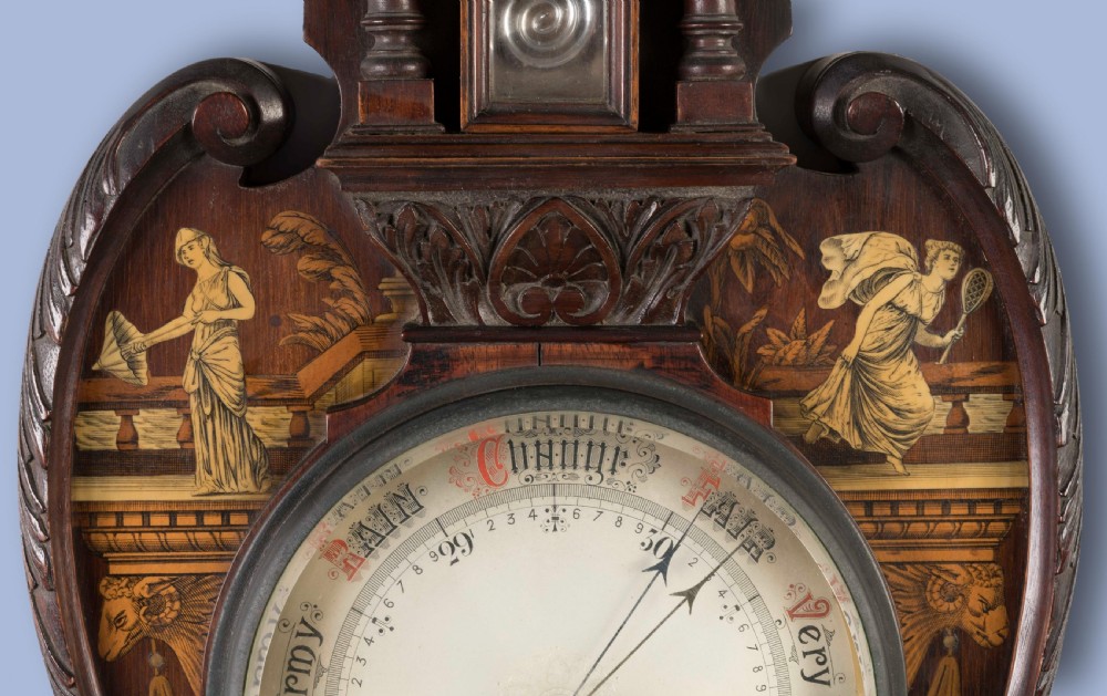 A Neoclassical mahogany wall barometer featuring detailed marquetry inlay of classical figures, a thermometer tube, and a circular weather dial. View IV