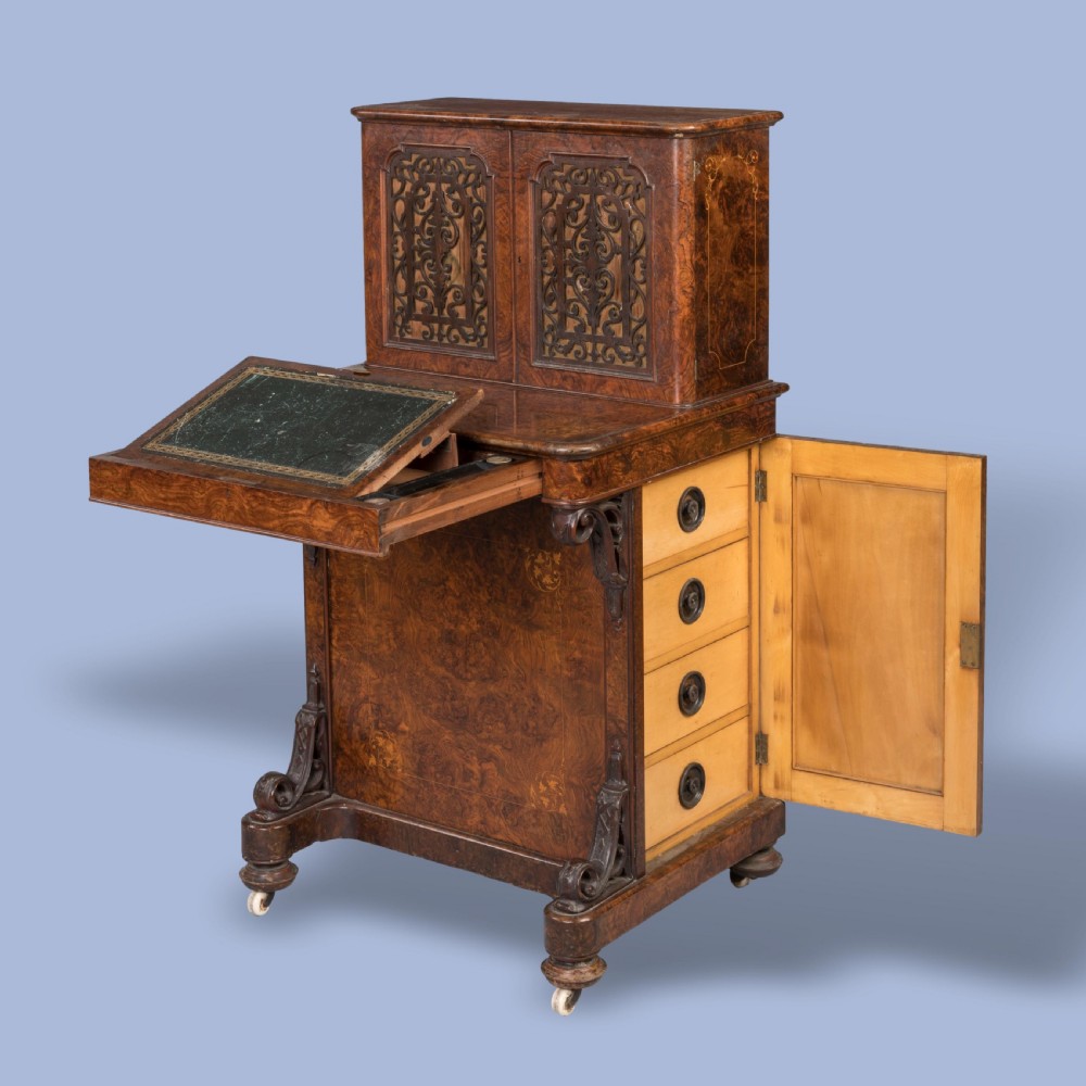 A mid-nineteenth-century Victorian burr walnut Davenport desk featuring pierced fretwork cabinet doors, floral marquetry inlay, carved scroll brackets, and ceramic castors. View III