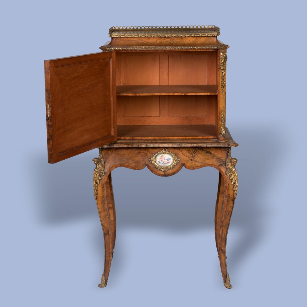 An English burr walnut cabinet on stand featuring cabriole legs, gilt-bronze mounts, a brass top gallery, and inset porcelain plaques. View III