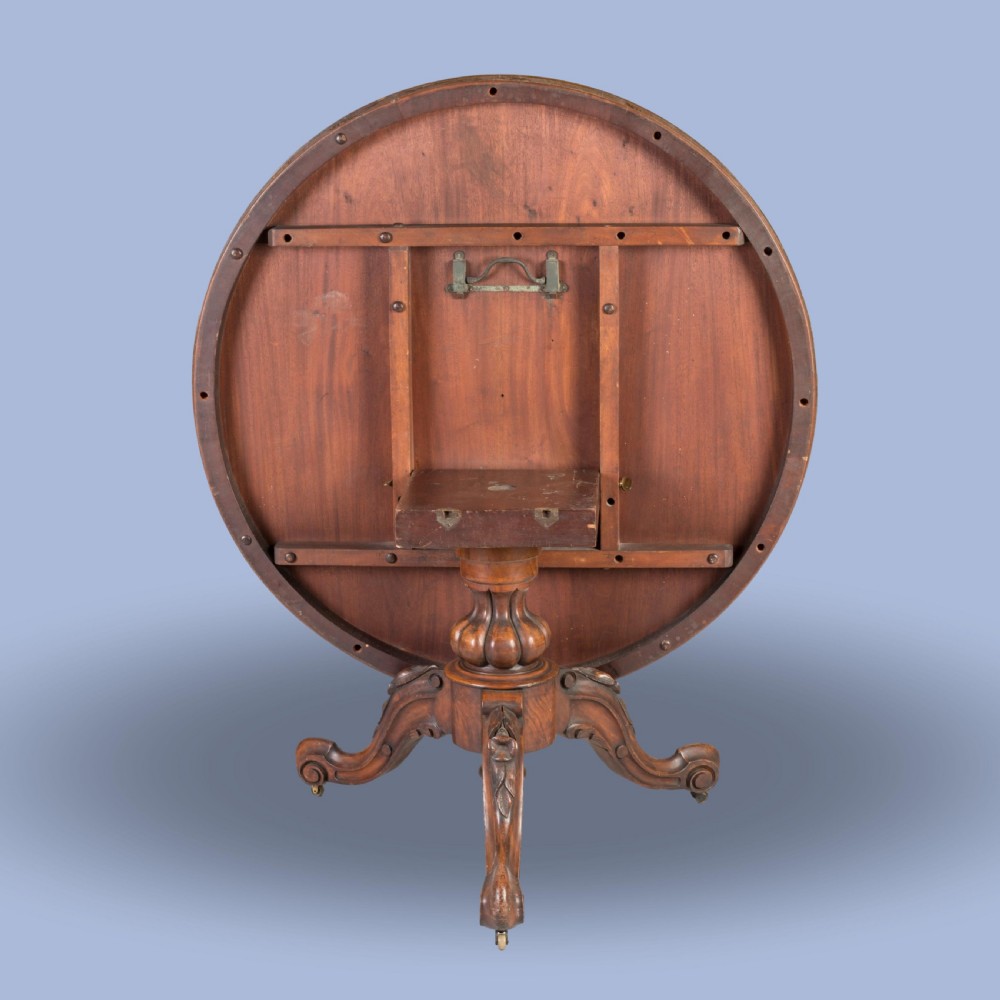 A circular Victorian walnut centre table featuring elaborate floral marquetry inlay set on a carved tripod base. View V