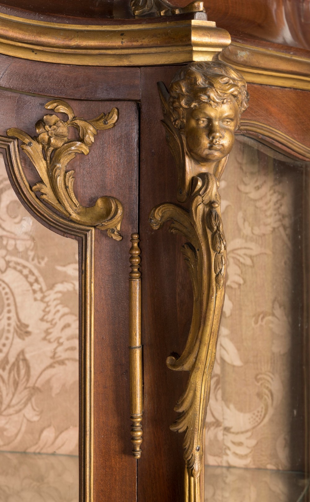 A French Transitional style bombe vitrine featuring curved glazed sides, floral marquetry panels, cabriole legs, and ornate gilt-bronze mounts. View IV
