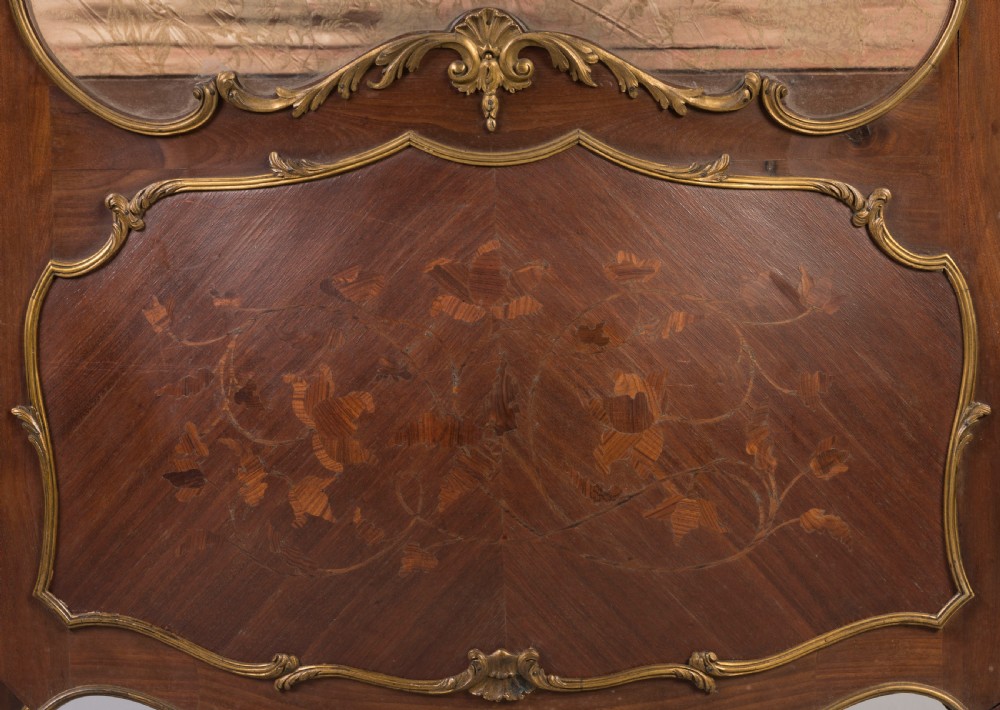 A French Transitional style bombe vitrine featuring curved glazed sides, floral marquetry panels, cabriole legs, and ornate gilt-bronze mounts. View V