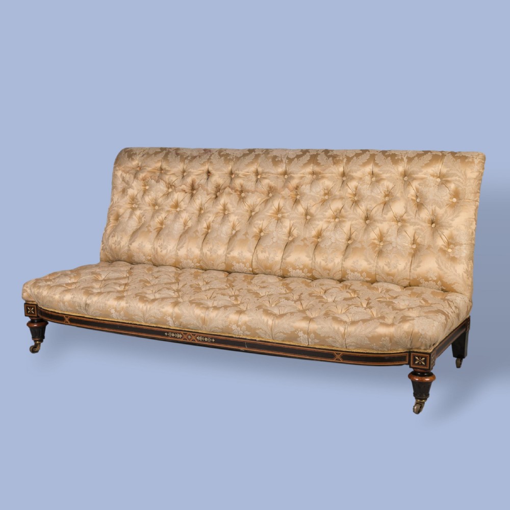 A LOW UPHOLSTERED SOFA IN THE EARLY AESTHETIC MANNER OF JACKSON & GRAHAM