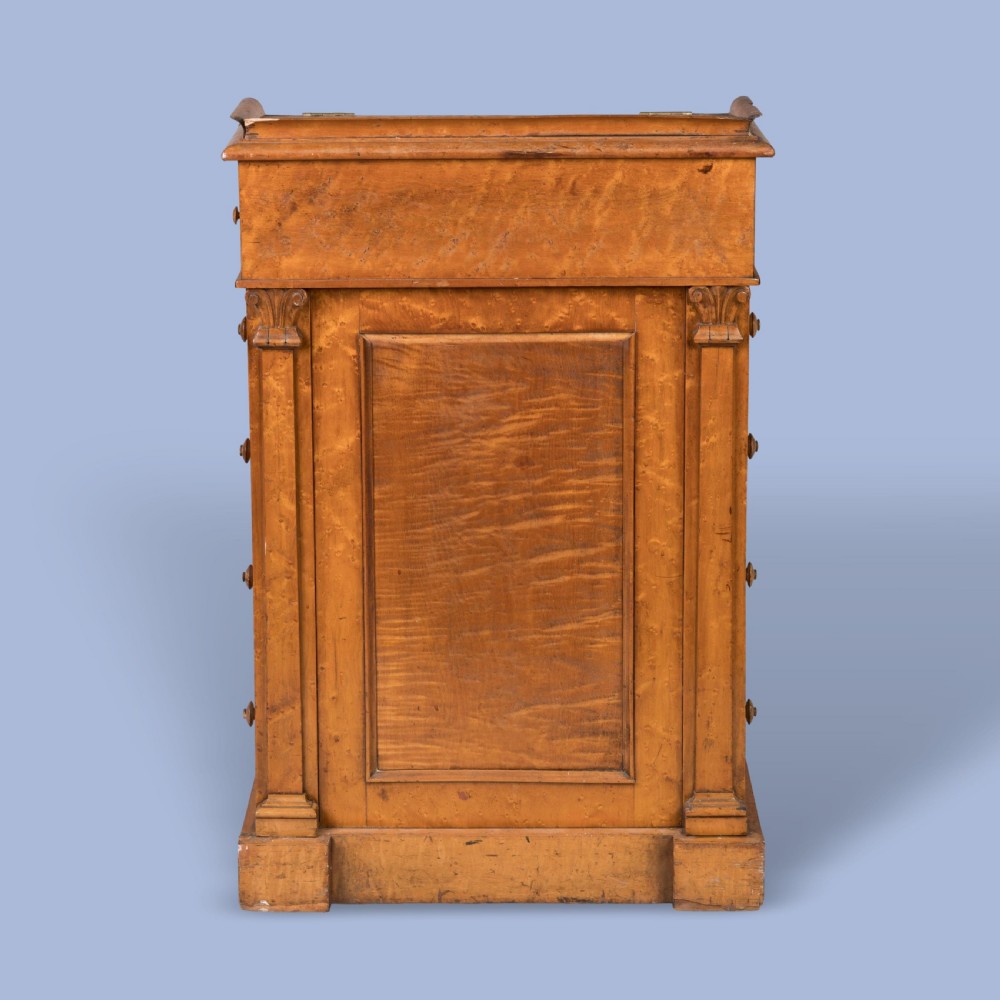 A late Georgian davenport desk crafted from golden timber with a sliding slanted leather writing top, side drawers with turned wooden knobs, and an extended side pen drawer. View II