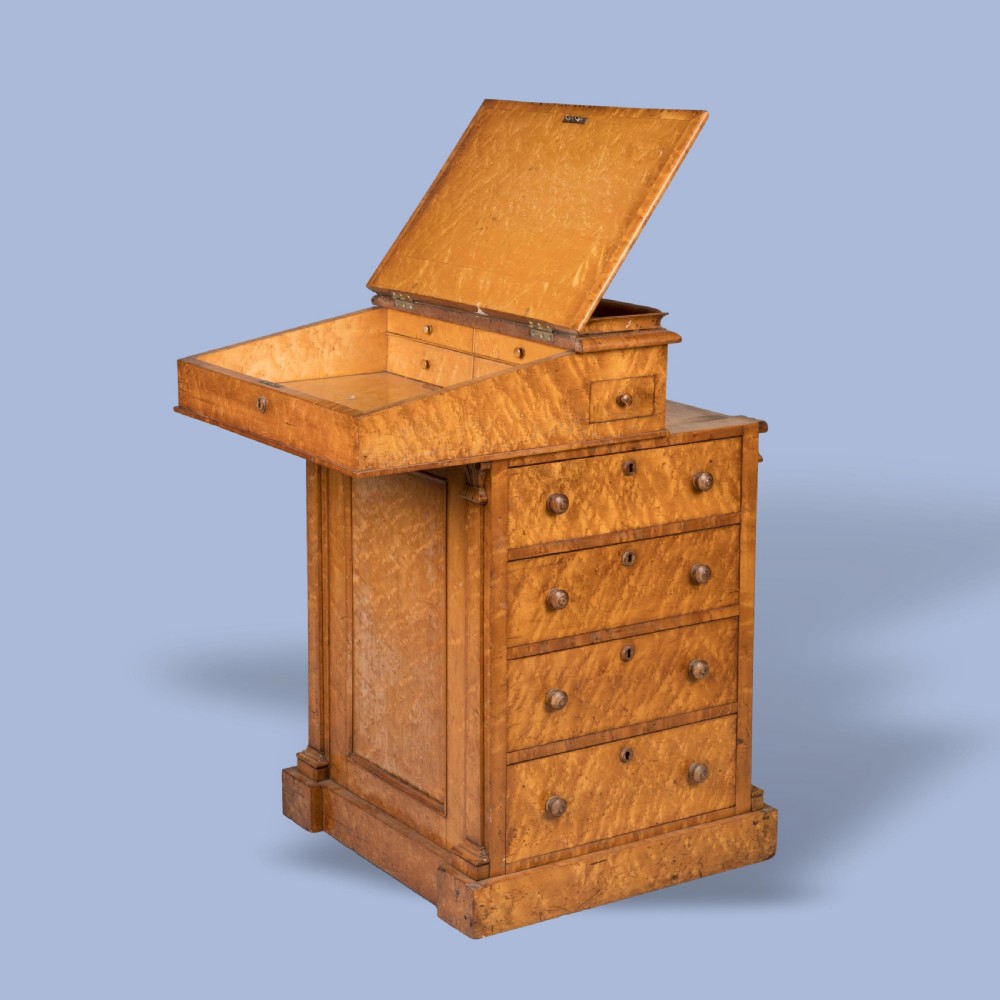 A late Georgian davenport desk crafted from golden timber with a sliding slanted leather writing top, side drawers with turned wooden knobs, and an extended side pen drawer. View IV