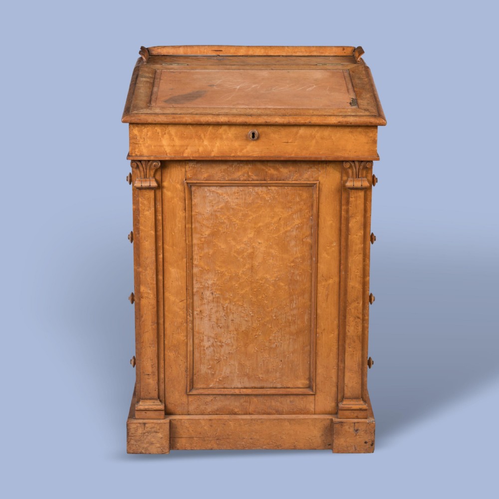 A late Georgian davenport desk crafted from golden timber with a sliding slanted leather writing top, side drawers with turned wooden knobs, and an extended side pen drawer. View V
