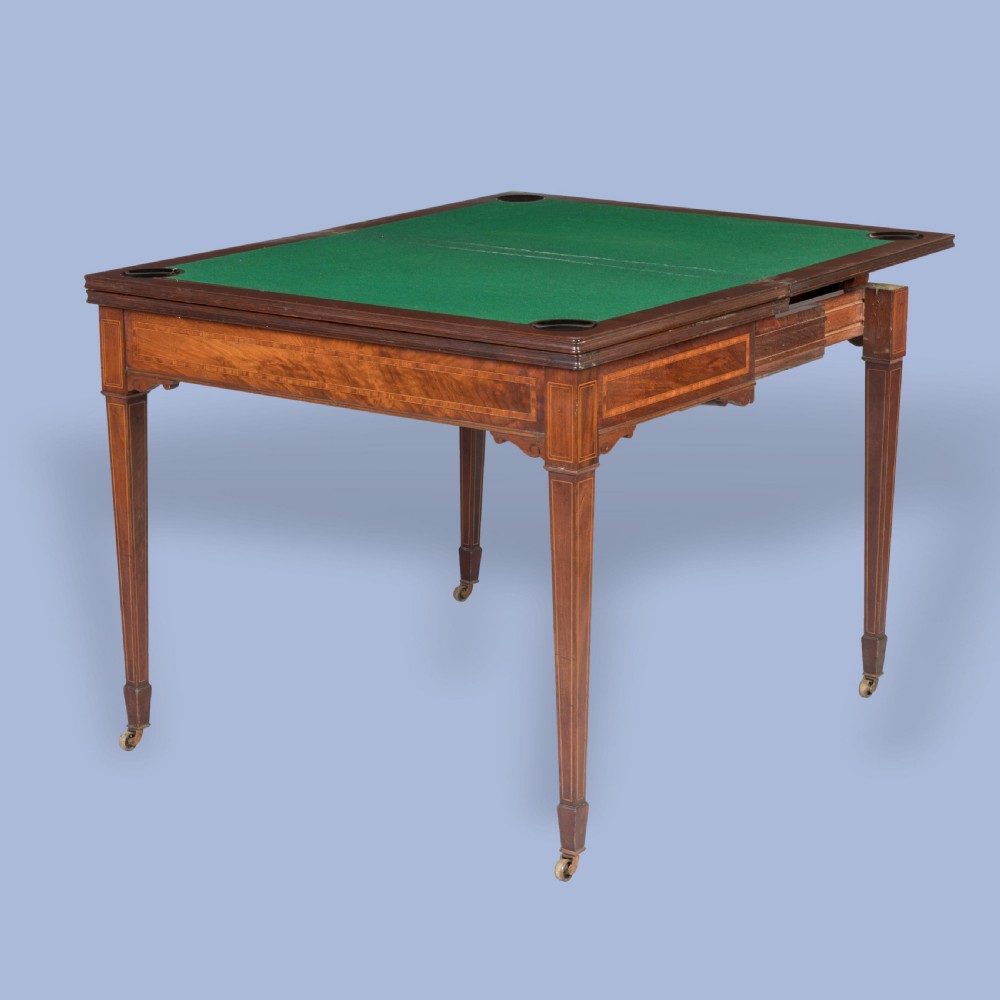 An Edwardian inlaid mahogany games table with square tapered legs, brass castors, and satinwood stringing. View III