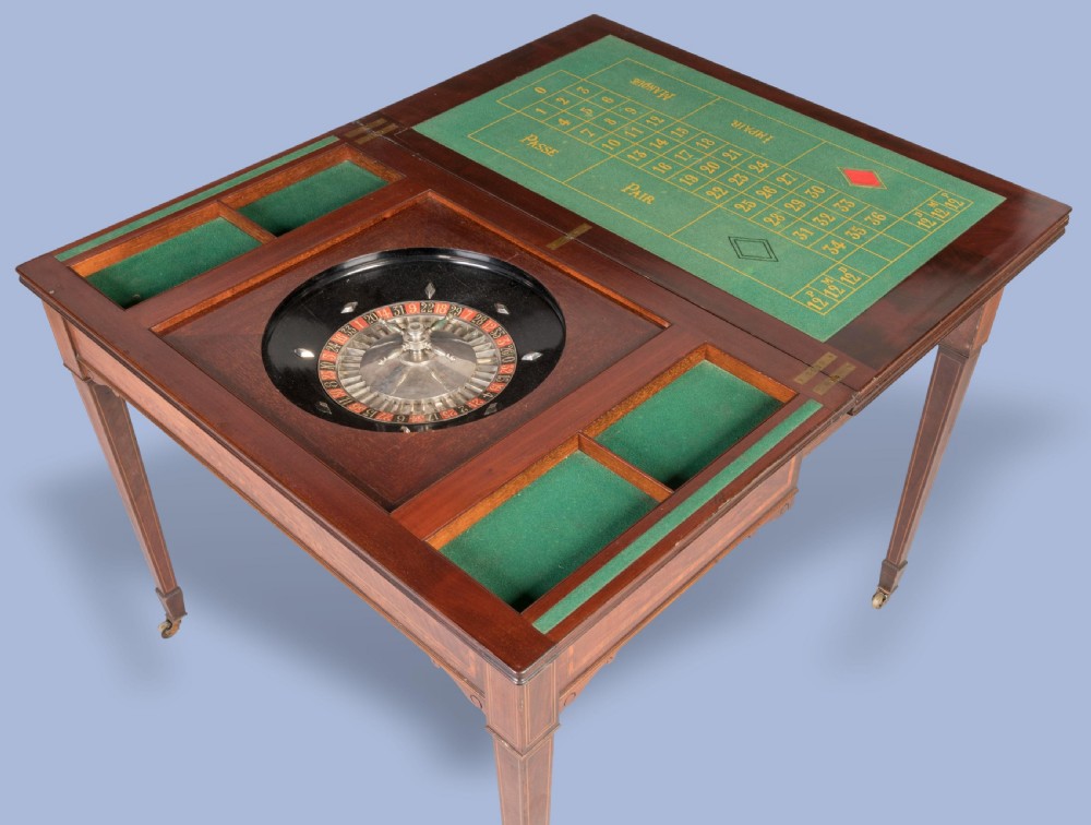 An Edwardian inlaid mahogany games table with square tapered legs, brass castors, and satinwood stringing. View IV