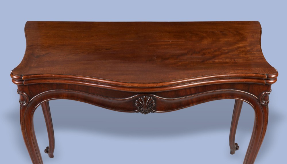 A Georgian mahogany fold-over card table featuring slender cabriole legs, a carved shell central apron motif, and a serpentine front. View V