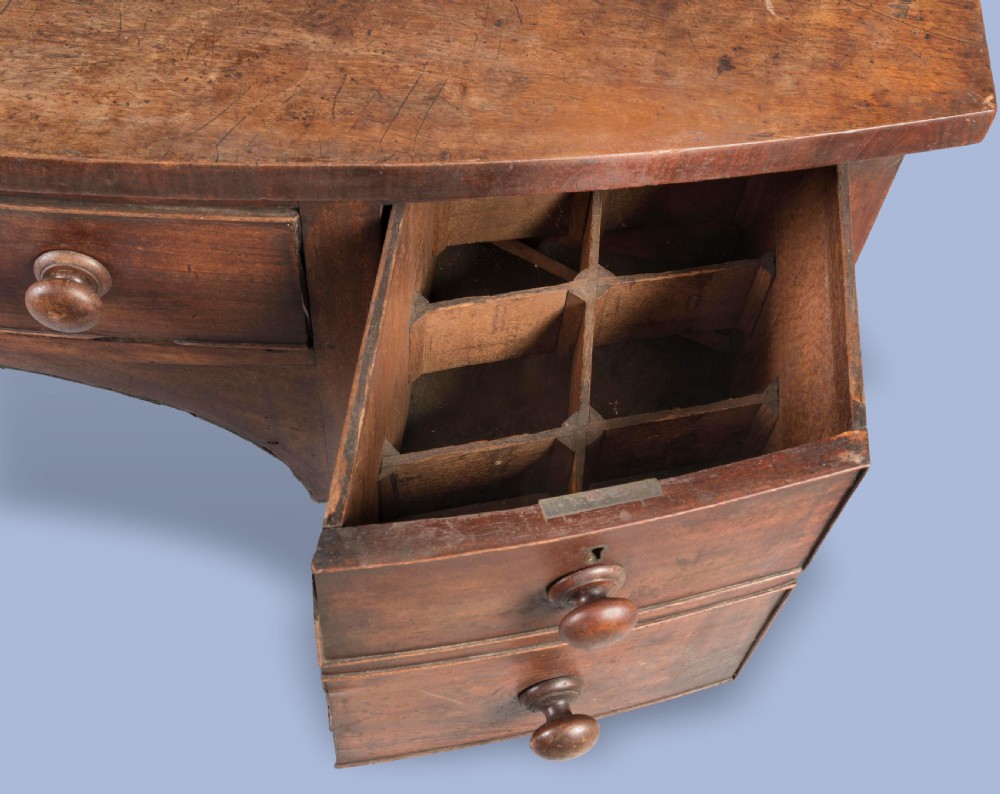 A Georgian mahogany bowfront sideboard featuring a central drawer flanked by side drawers, supported on square tapered legs with spade feet. View III